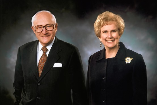 Photo of a smiling elderly man and his not-quite-as-elderly wife