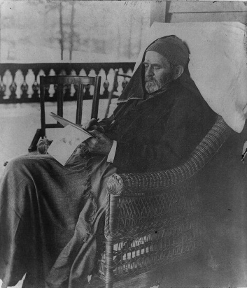 Photo of President Grant in stocking cap, looking weak, with a writing pad in his hands