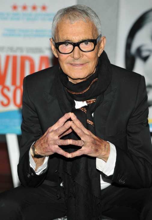 Photo of Vidal Sassoon, putting his hands in a tent, looking gray but smiling