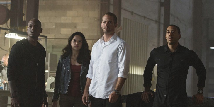 A photo of the cast of Furious 7 standing side-by-side and looking serious and tough