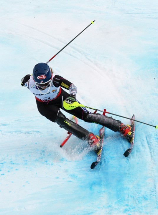 Photo of Mikaela Shiffrin charging down a slalom course over blue-tinted snow