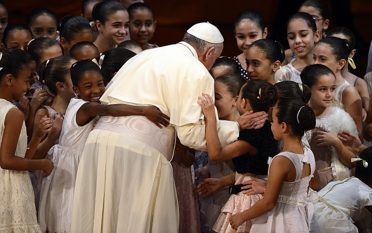 Pope Francis photo, with him hugging schoolkids gathered around