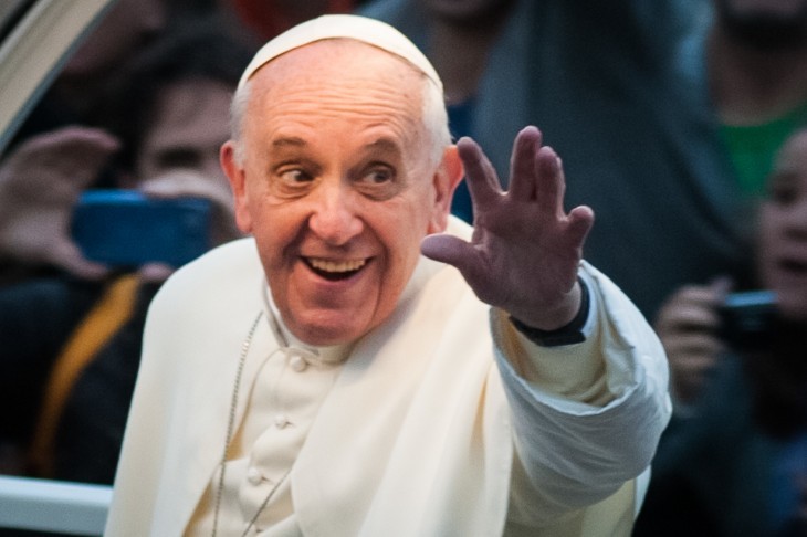 Pope Francis photo, with the pope reaching out a hand and smiling at crowds