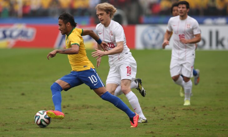 A photo of Neymar running across green grass with the ball