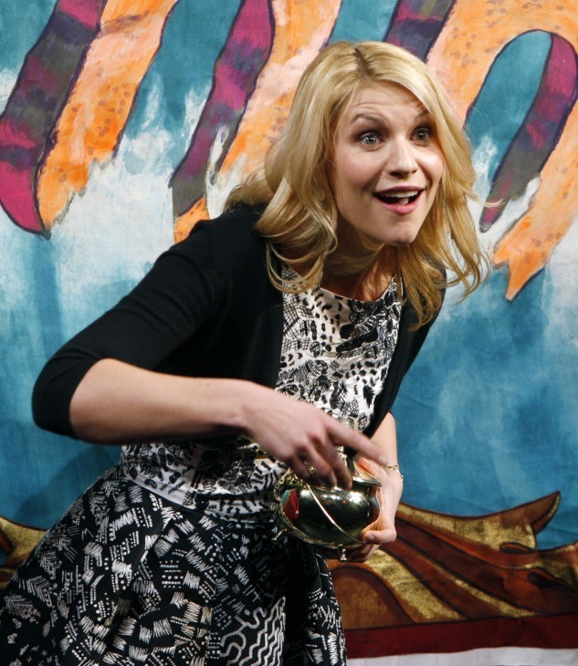 Claire Danes photo, mugging for the audience as she holds a small gold pot