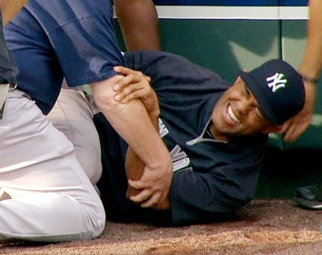 A photo of Mariano Rivera grimacing as he writhes on the outfield warning track