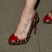 Daisy Ridley's feet in high heels with leopard spots and a red heart toe cap, showing a tattoo of three stars running down toward her toes on the top of her her left foot