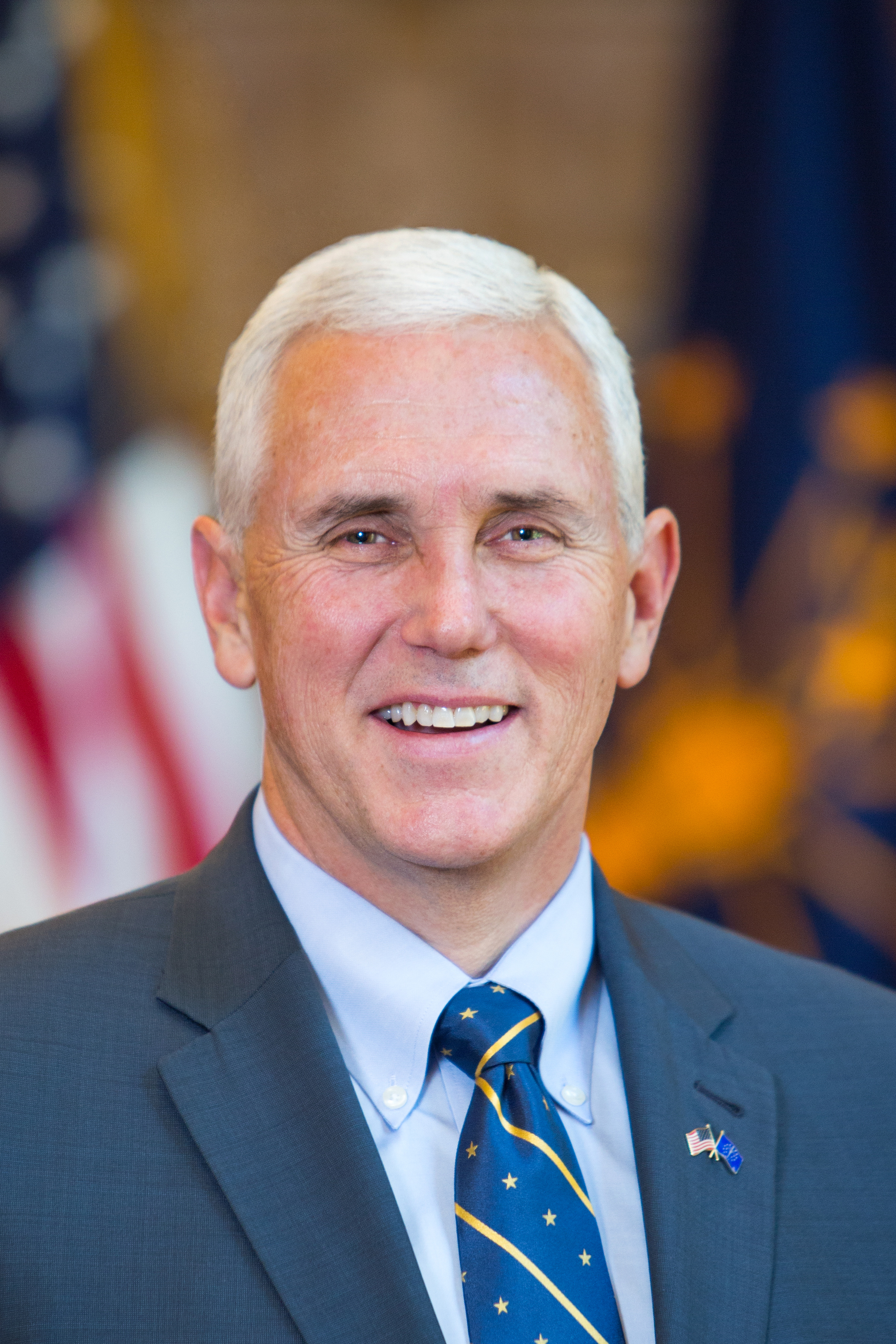 Mike Pence smiles in a blue tie and blue jacket