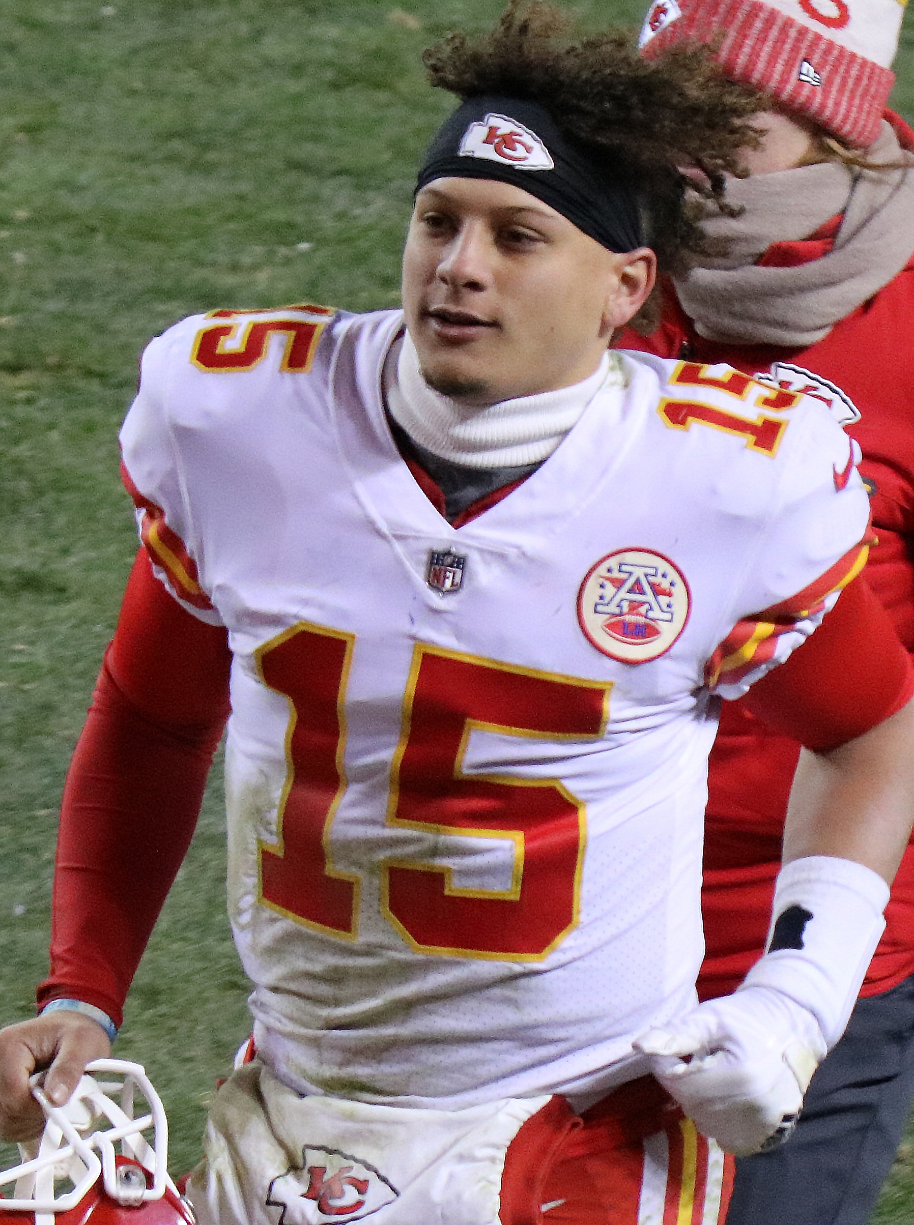 Patrick Mahomes looks young as he jogs off the field in his white Kansas City Chiefs uniform. His hair sticks up in a shock atop a headband.