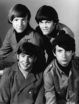 Four smiling young men pose together in a square for a basic publicity photograph