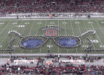 A marching band forms aviator sunglasses on a football field